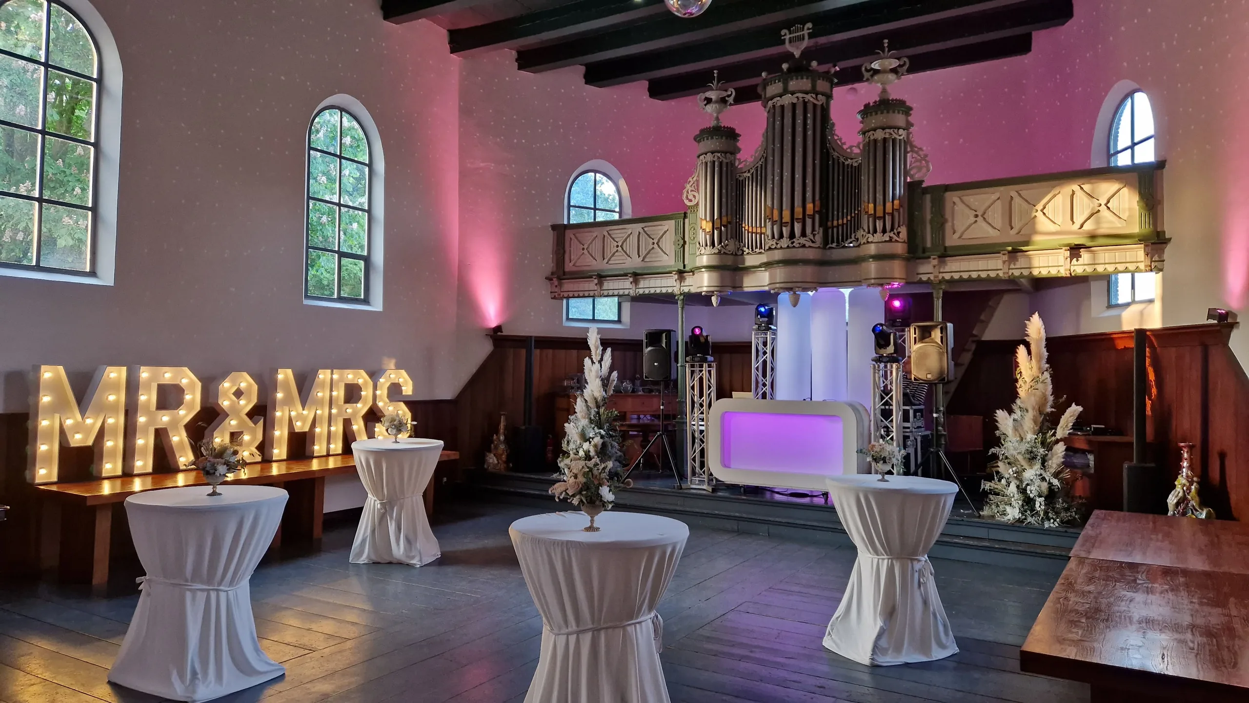 Bruiloftsopstelling met DJ-booth en MR&MRS-letters in de Amshoff