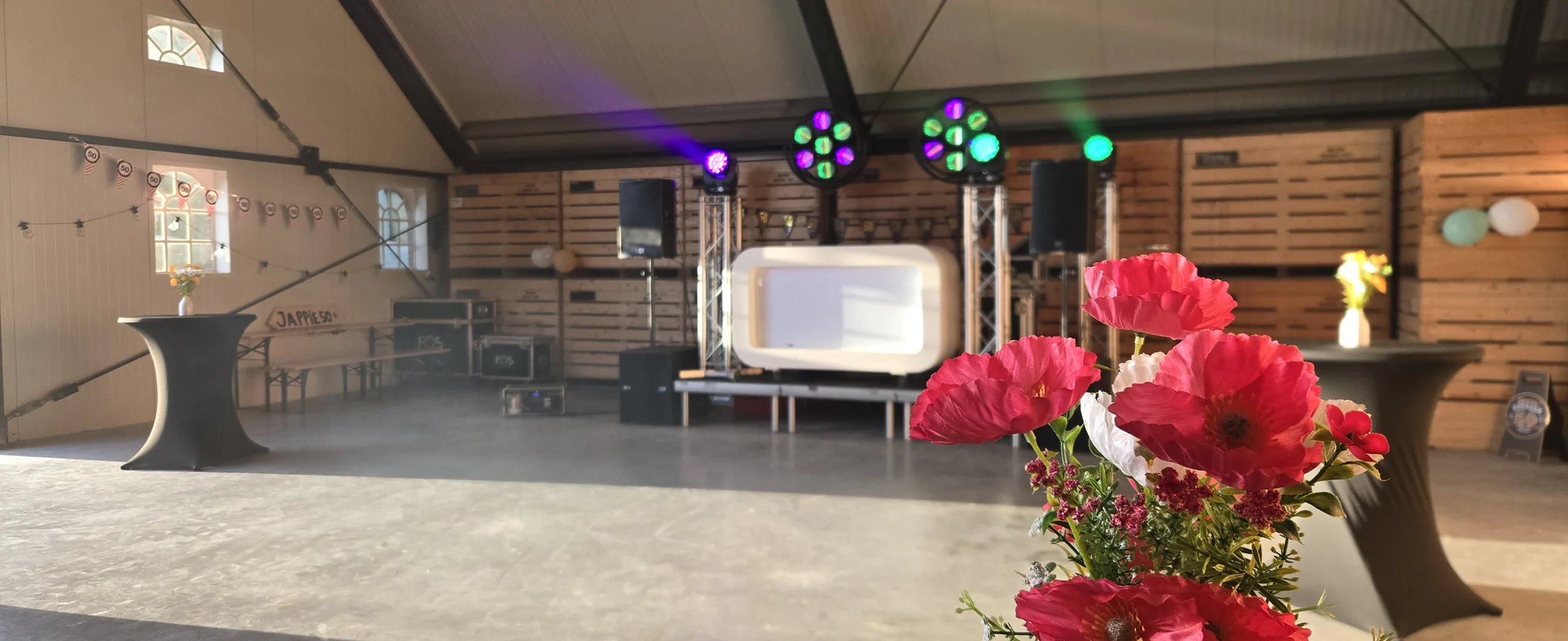 Witte DJ-booth met lichtset in een schuur, klaar voor een verjaardagsfeest