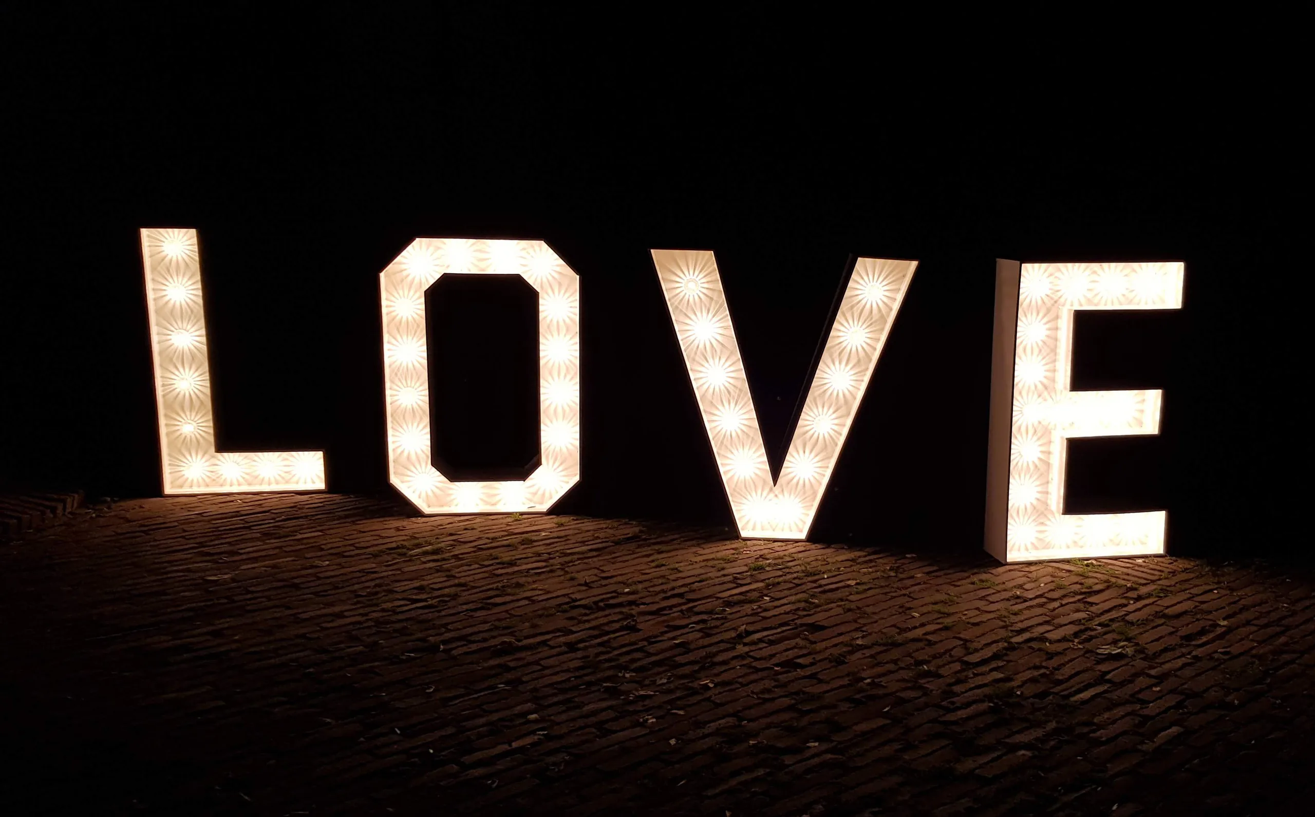 Verlichte LOVE-letters op een donkere klinkervloer