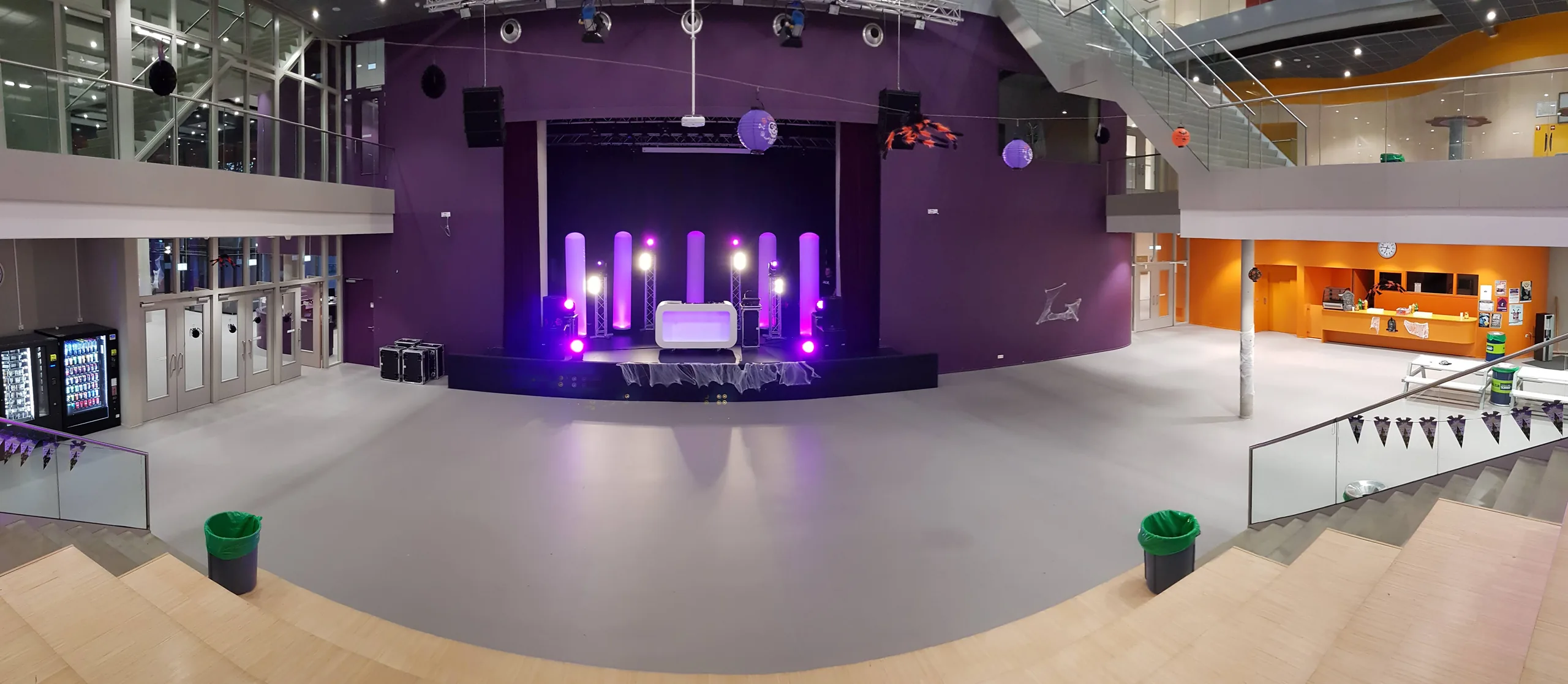 Podium met paarse belichting en lege dansvloer in de aula tijdens het schoolfeest in Haren
