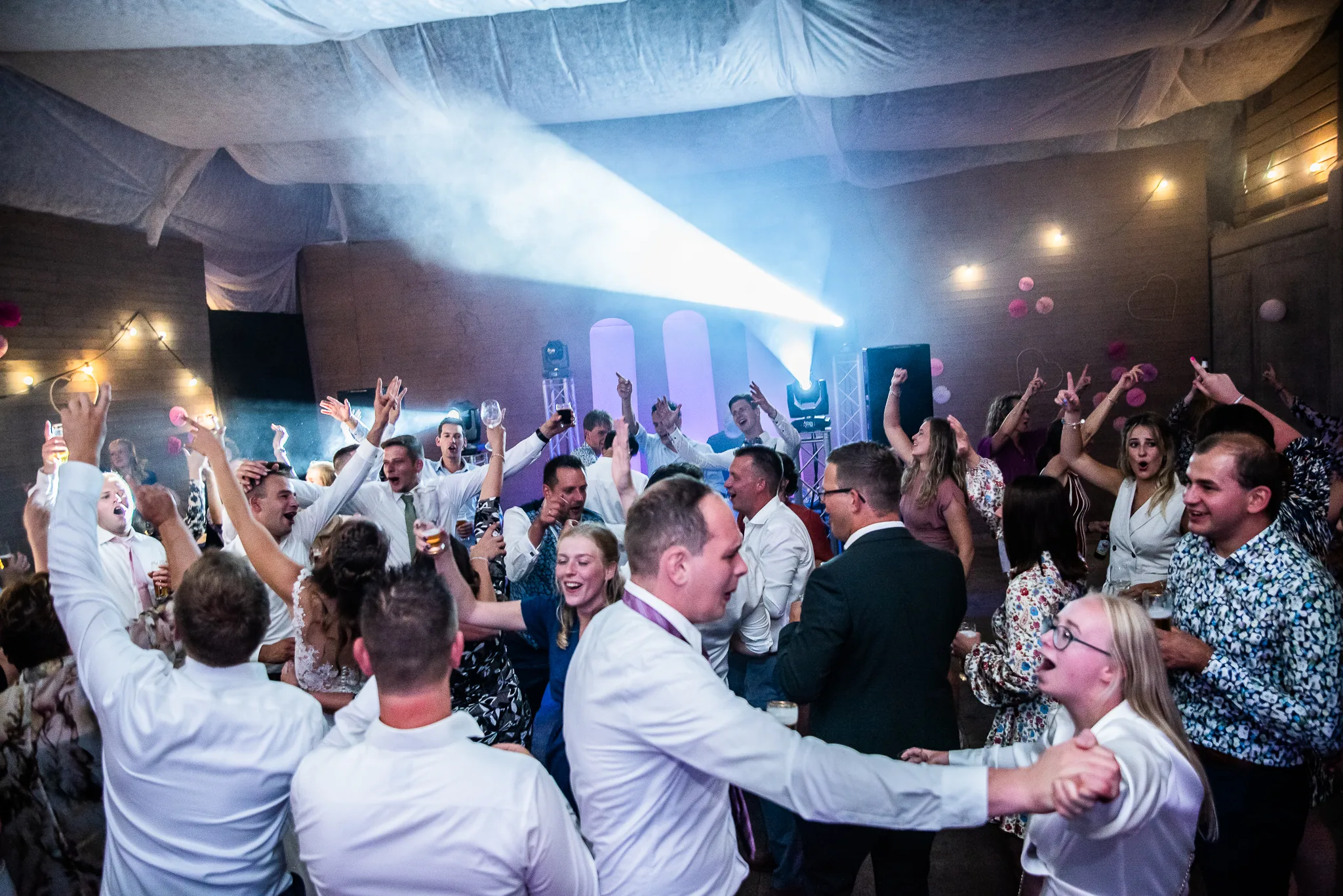 Volle dansvloer met dansende gasten tijdens een bruiloftsfeest