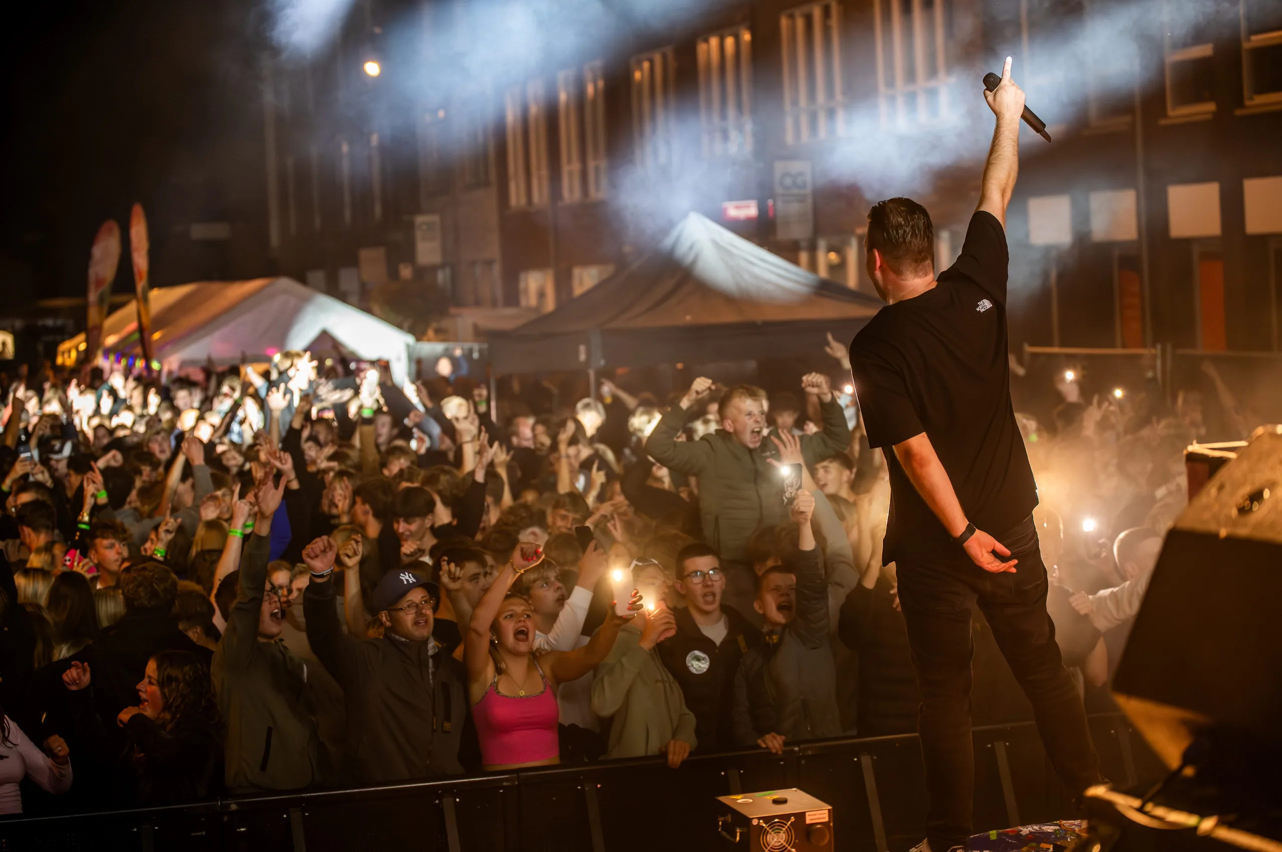 DJ met de microfoon omhoog voor het publiek tijdens Open Air Festival Grootegast
