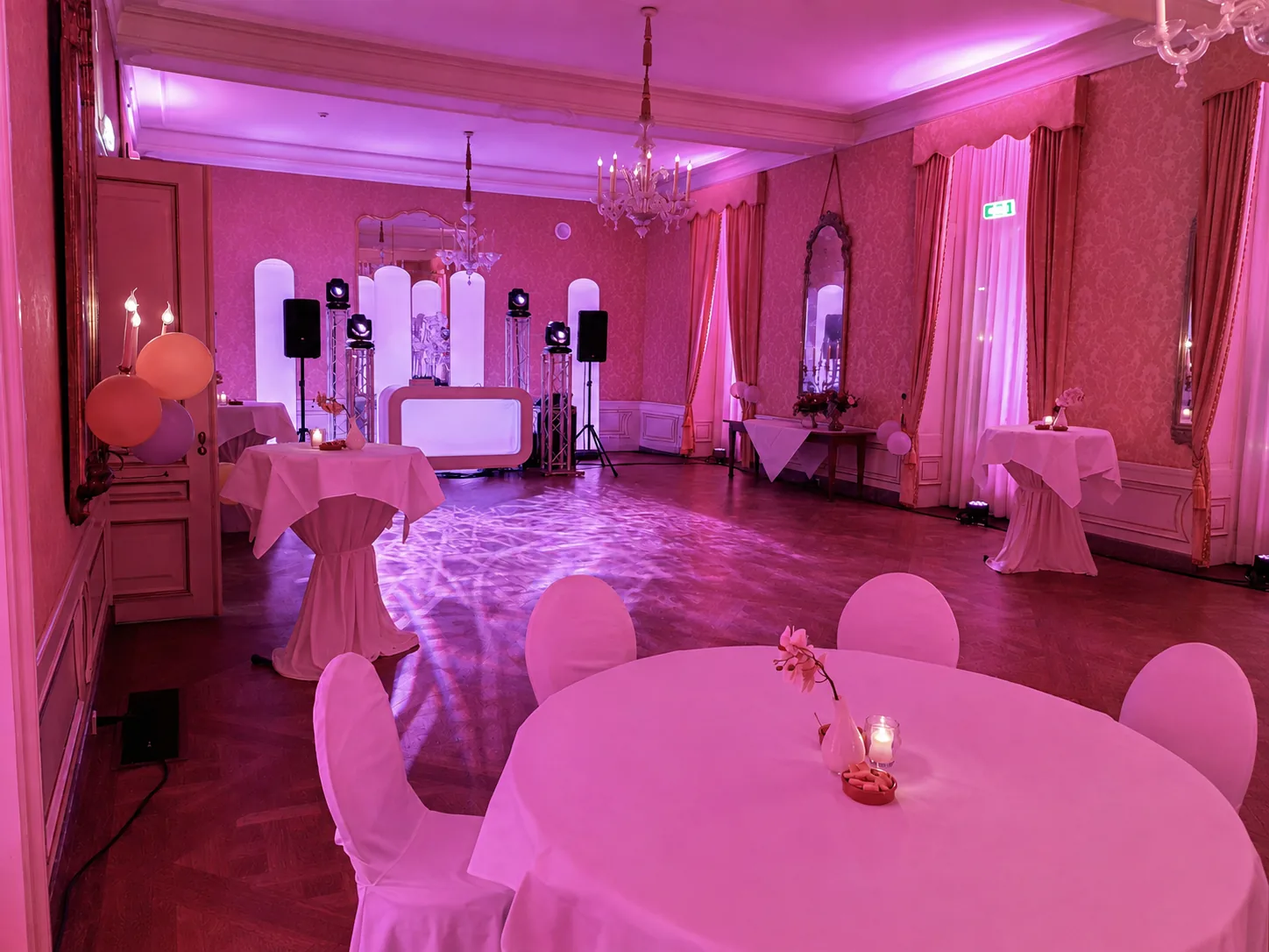 DJ-booth en gedekte tafels onder roze licht in het Stadhouderlijk Hof in Leeuwarden