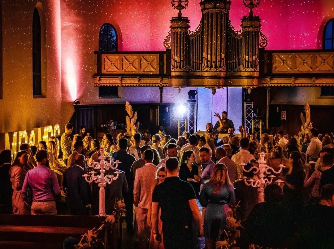 Volle dansvloer met bruiloftsgasten voor DJ Martijn Renkema onder het orgel van De Amshoff in Kiel-Windeweer
