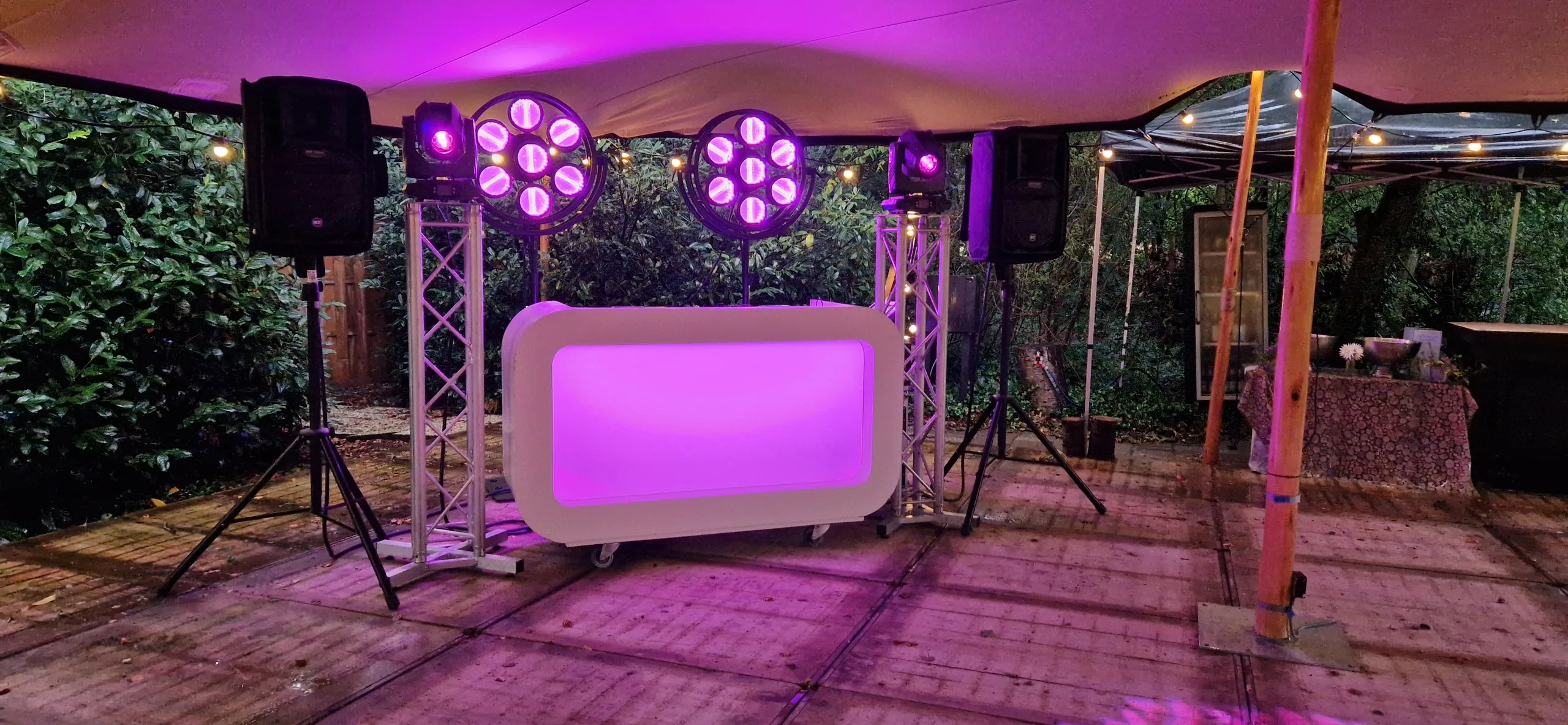 Verlichte DJ-booth met lichtset in de tuin, klaar voor een verjaardagsfeest