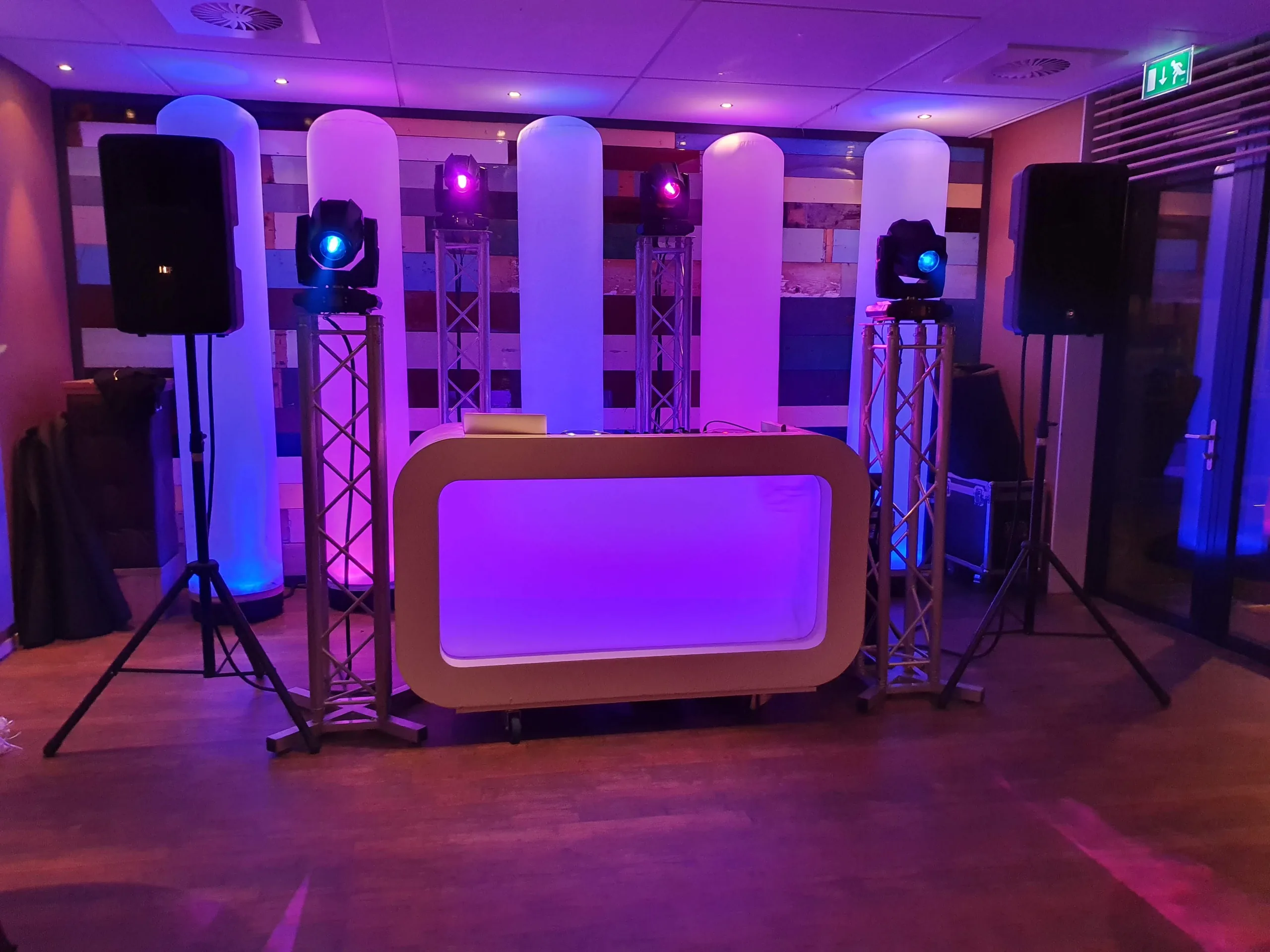 Verlichte DJ-booth met lichtzuilen, klaar voor een verjaardagsfeest