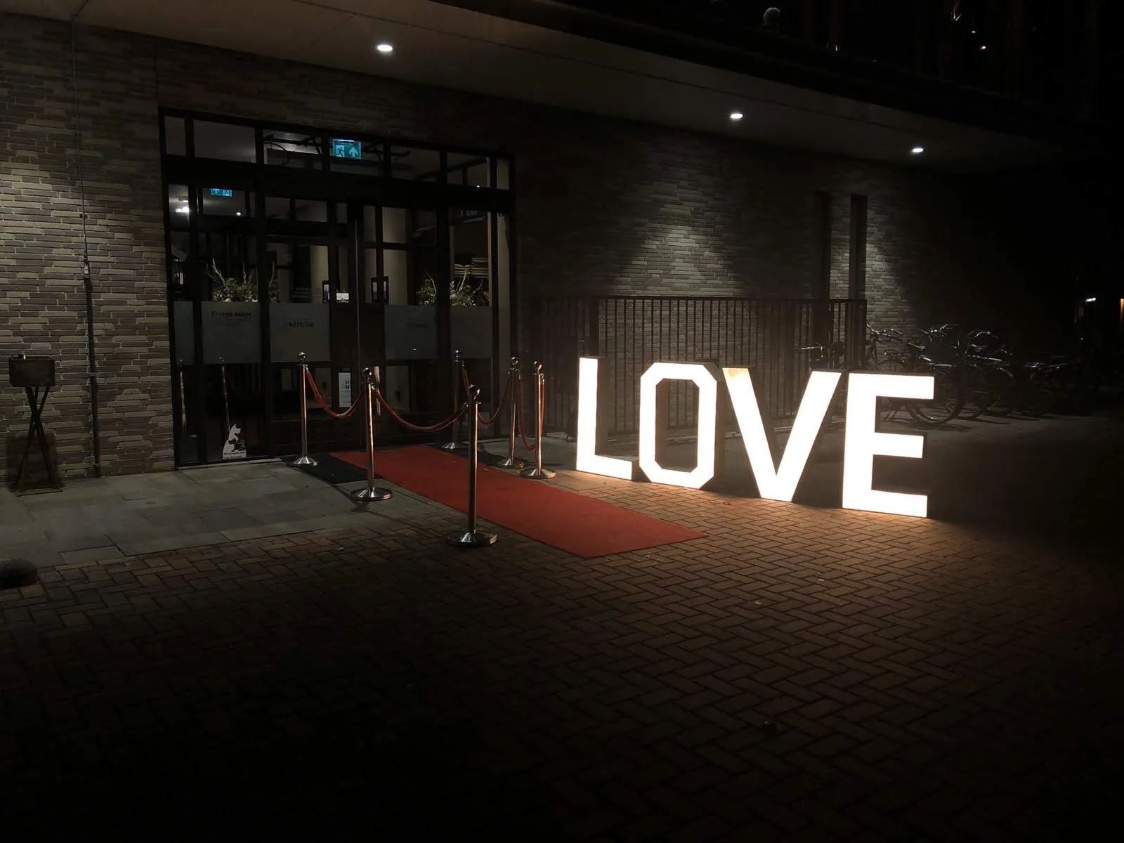 Verlichte LOVE letters op een rode loper bij de ingang