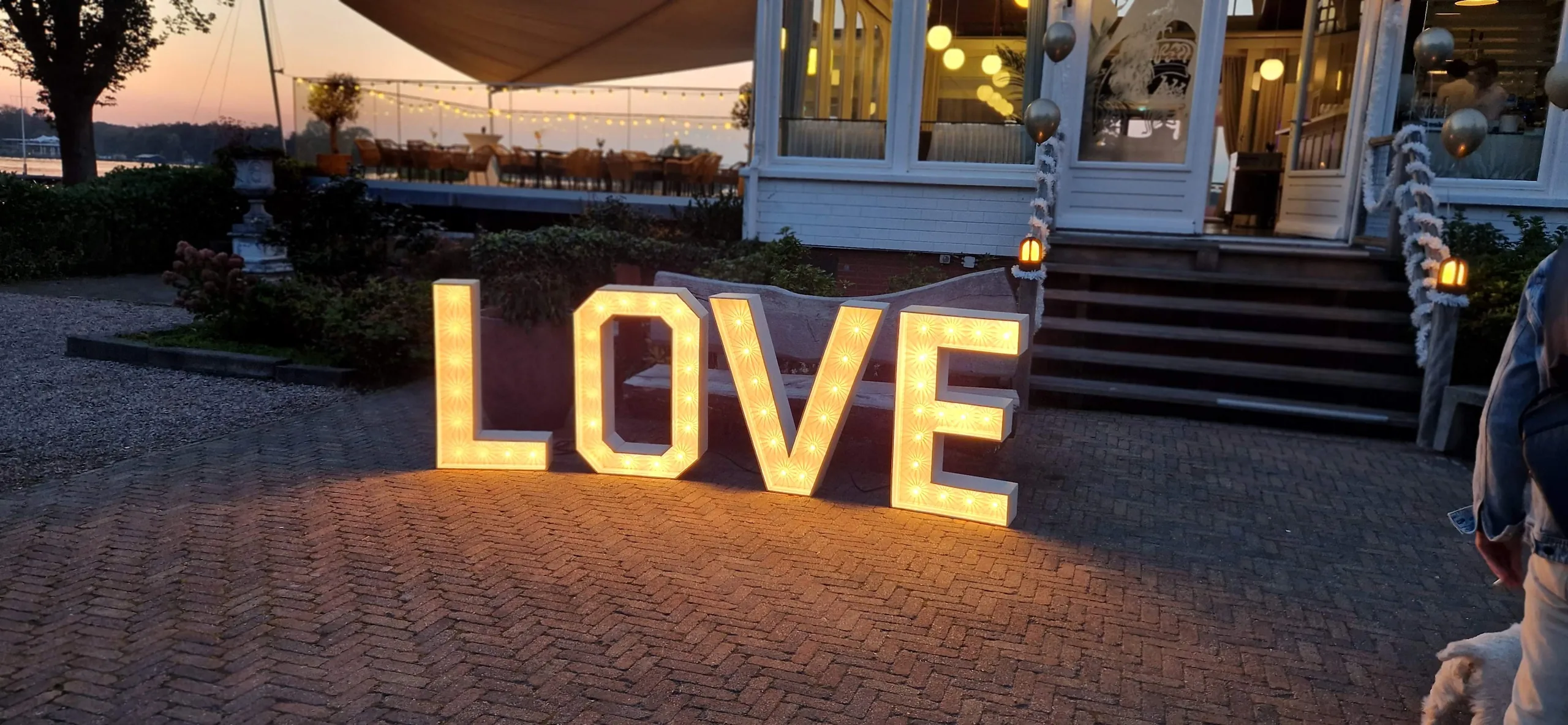 Verlichte LOVE letters op een binnenplaats bij schemer