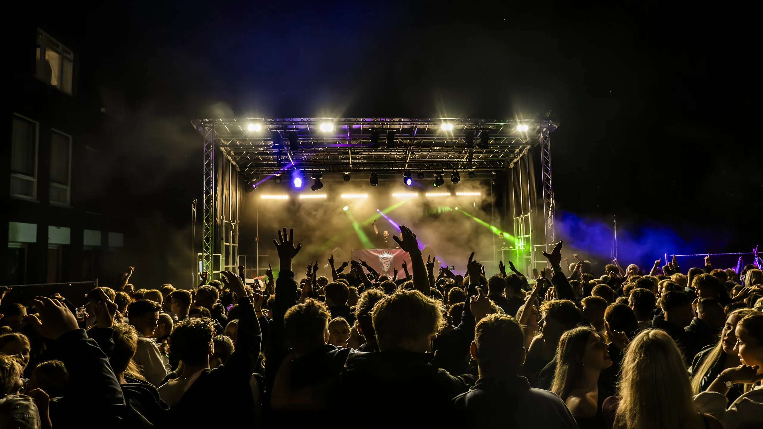 Verlicht openluchtpodium met publiek tijdens Open Air Festival Grootegast