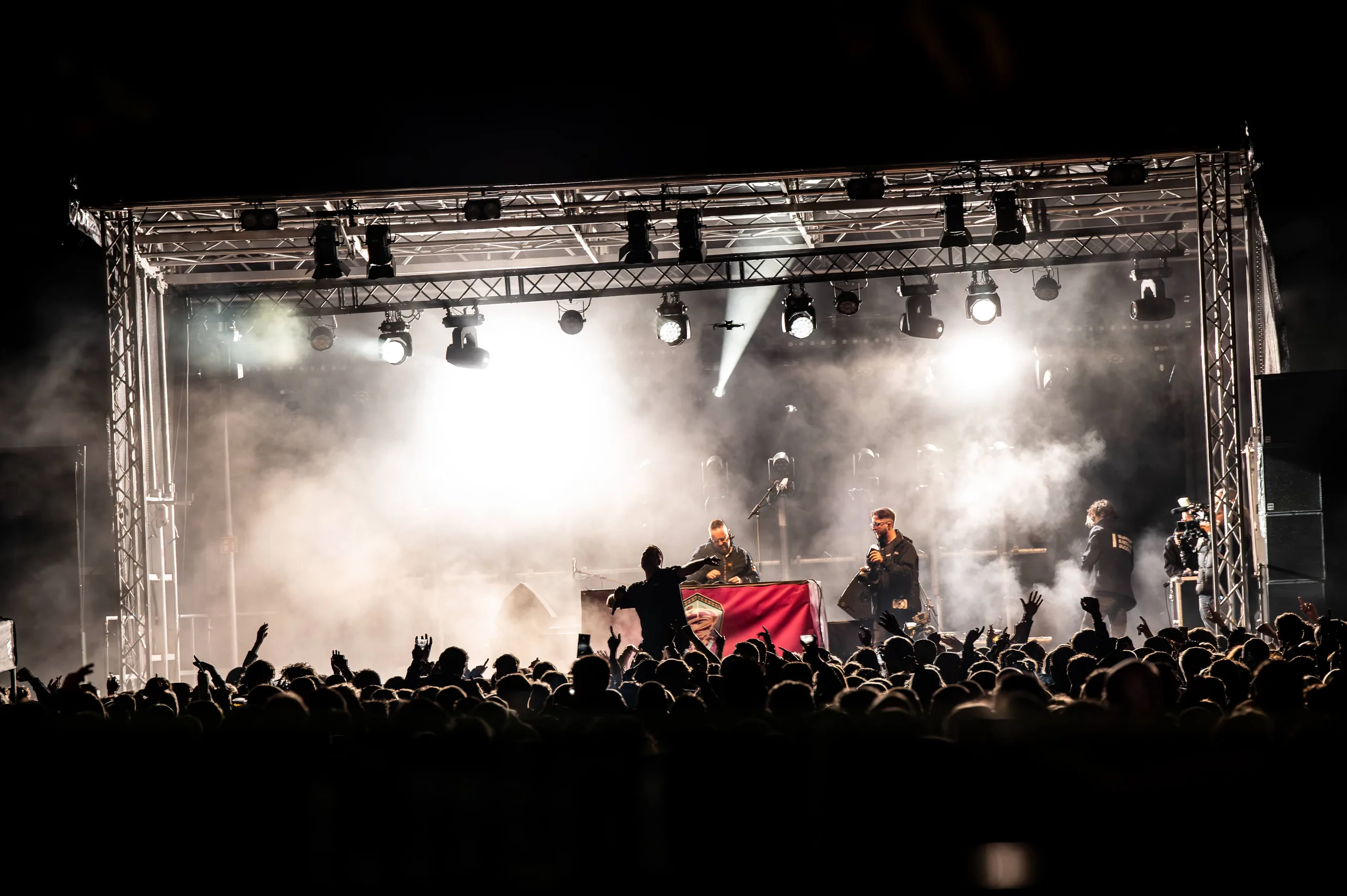 Podium met lichtset en rook, gezien vanaf het publiek tijdens een feest